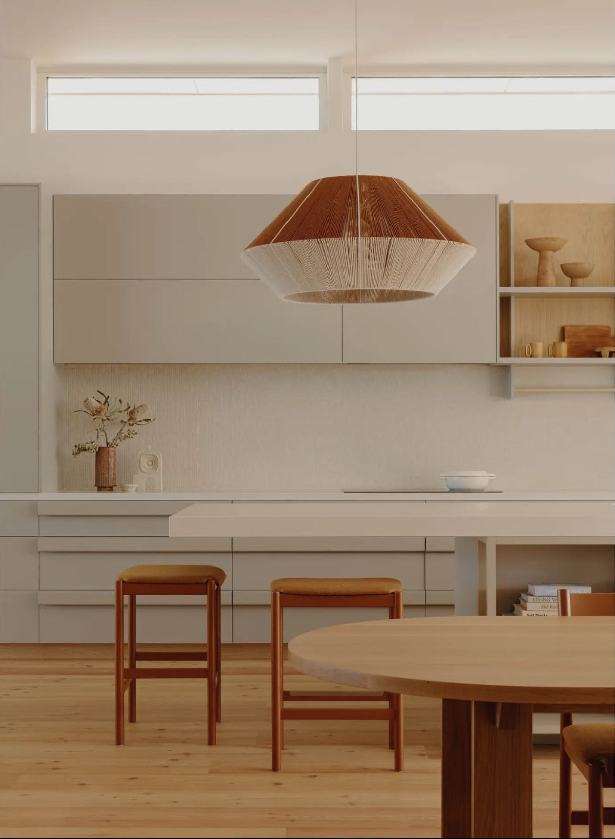 Large woven pendant by Skye Lightly installed above a kitchen island in a Fabrikate-designed contemporary interior.