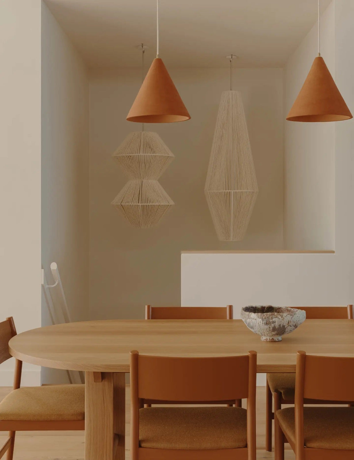 Two large woven pendants by Skye Lightly suspended in a stairwell. Interior design by Fabrikate.