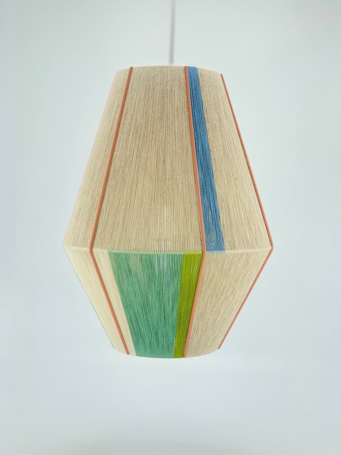 Side angle view of Alice Baya pendant light showing multi-colour yarn pattern over natural base.