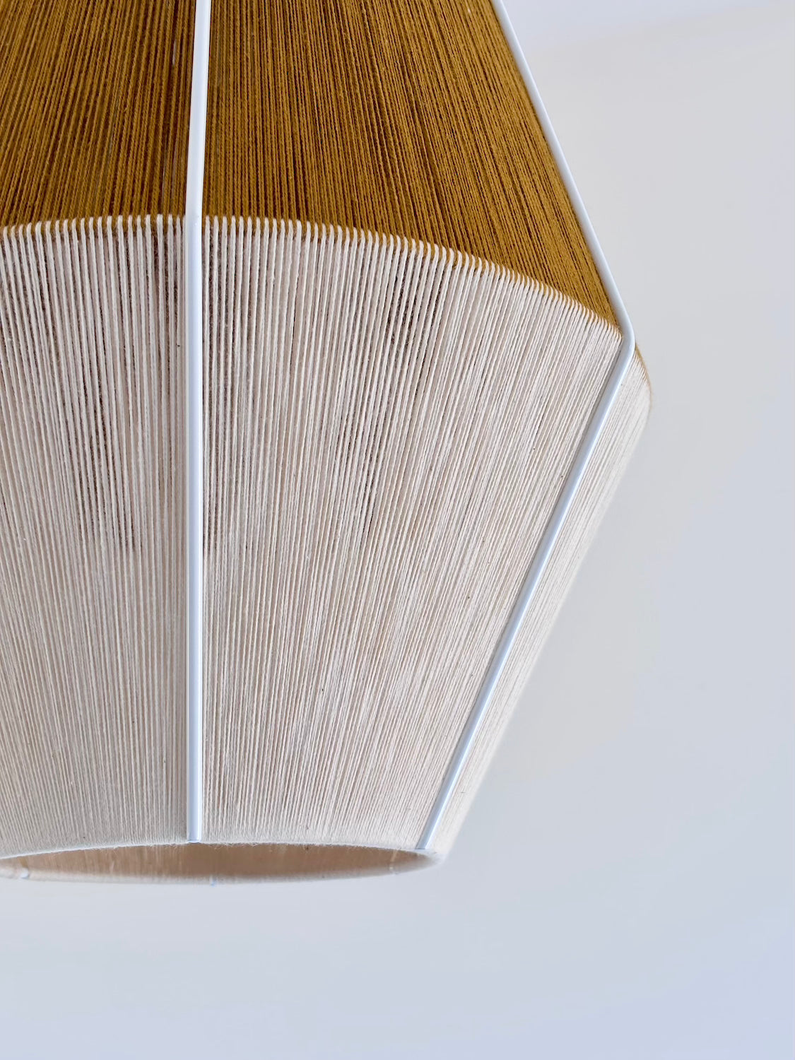 Bottom view of handwoven Baya pendant light in mustard and natural colours by Skye Lightly.