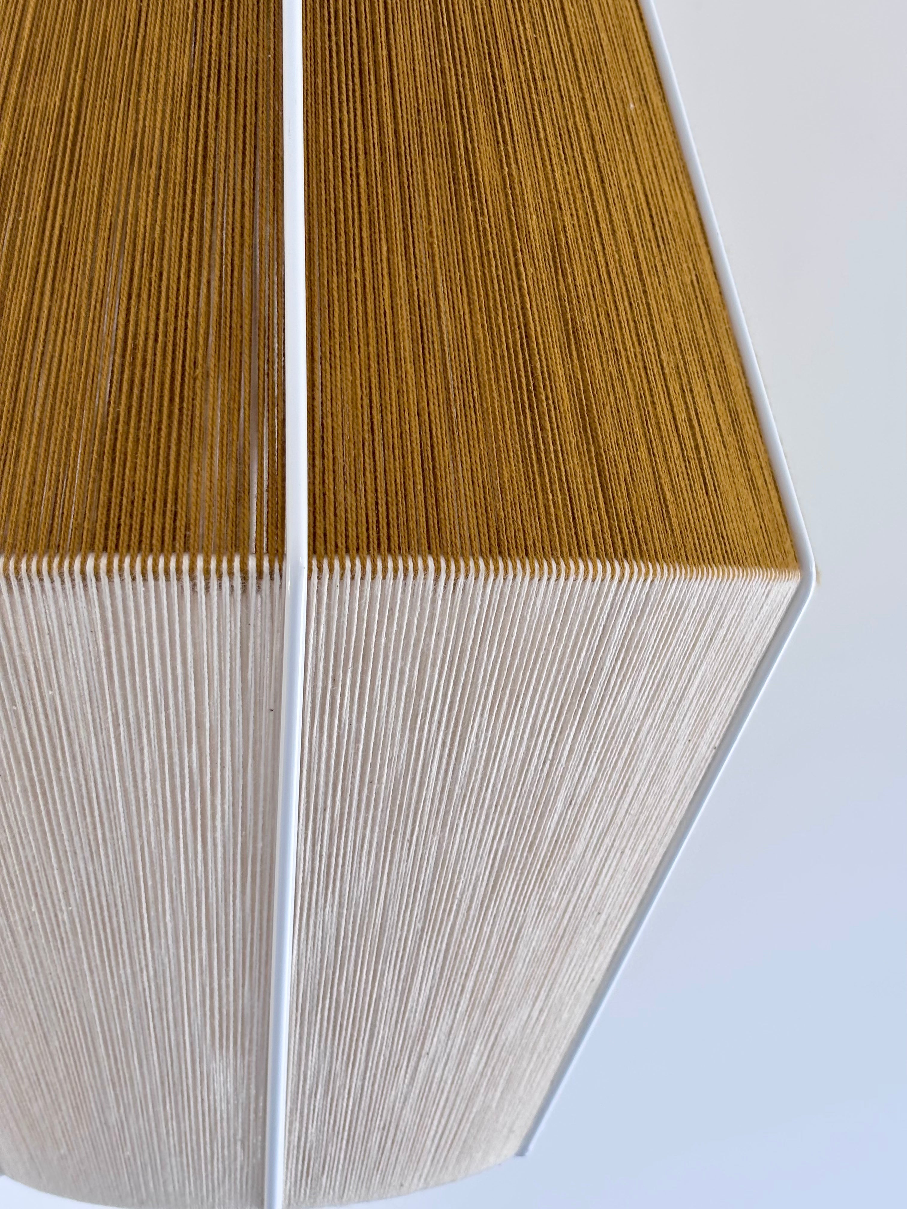 Closeup view of handwoven Baya pendant light in mustard and natural colours by Skye Lightly.