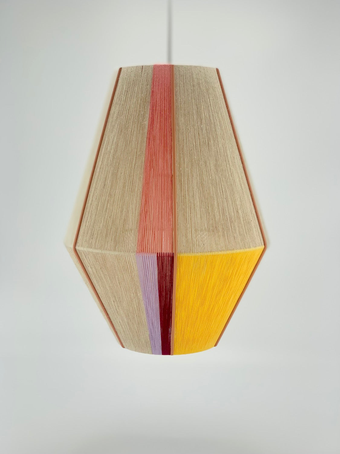 Caroline Baya pendant light handwoven in salmon, lavender, yellow, raspberry and natural yarns by Skye Lightly.