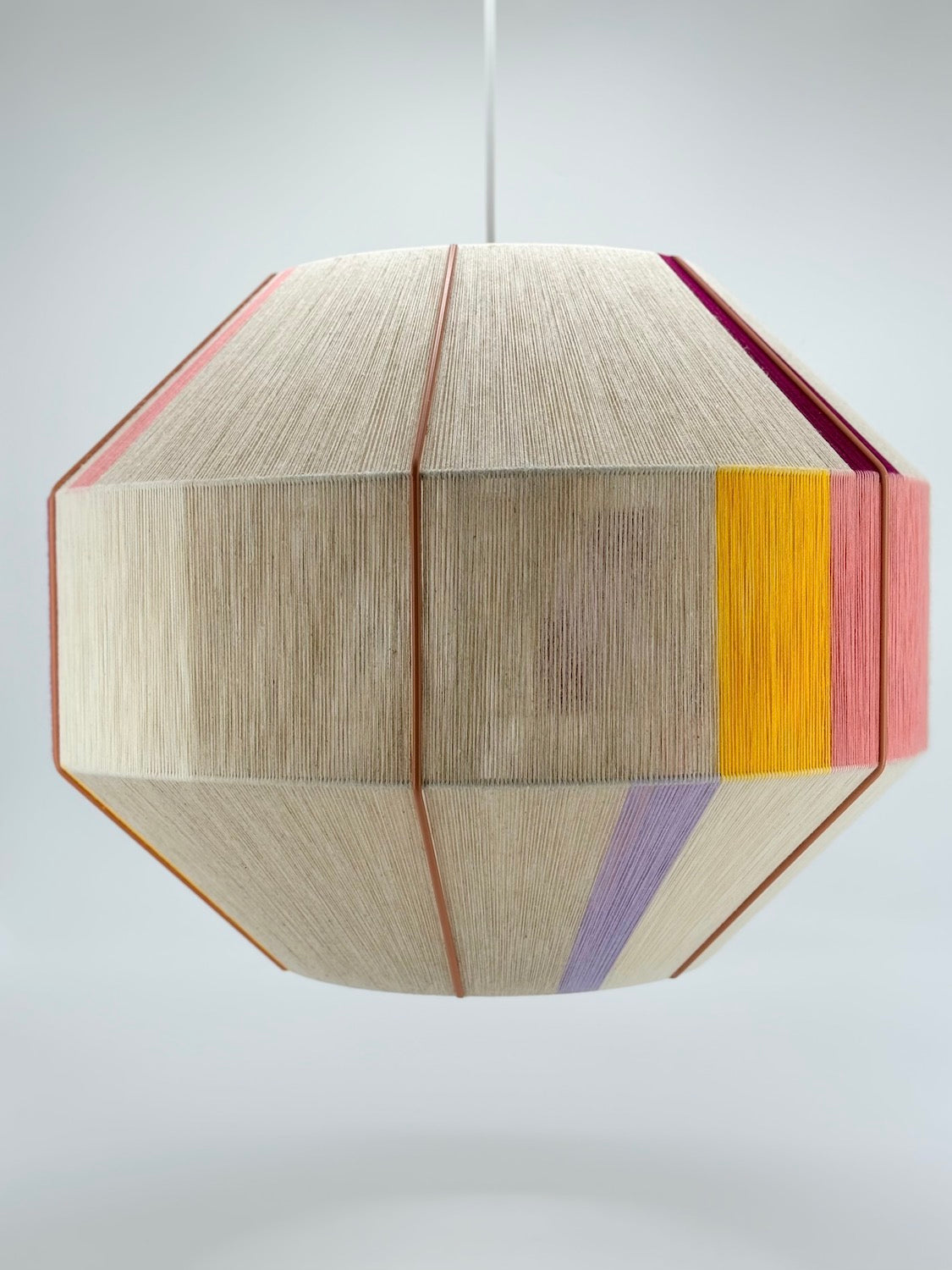 Centre view of Bella Hive pendant light handwoven in salmon, lavender, buttercup yellow, raspberry and natural yarns by Skye Lightly