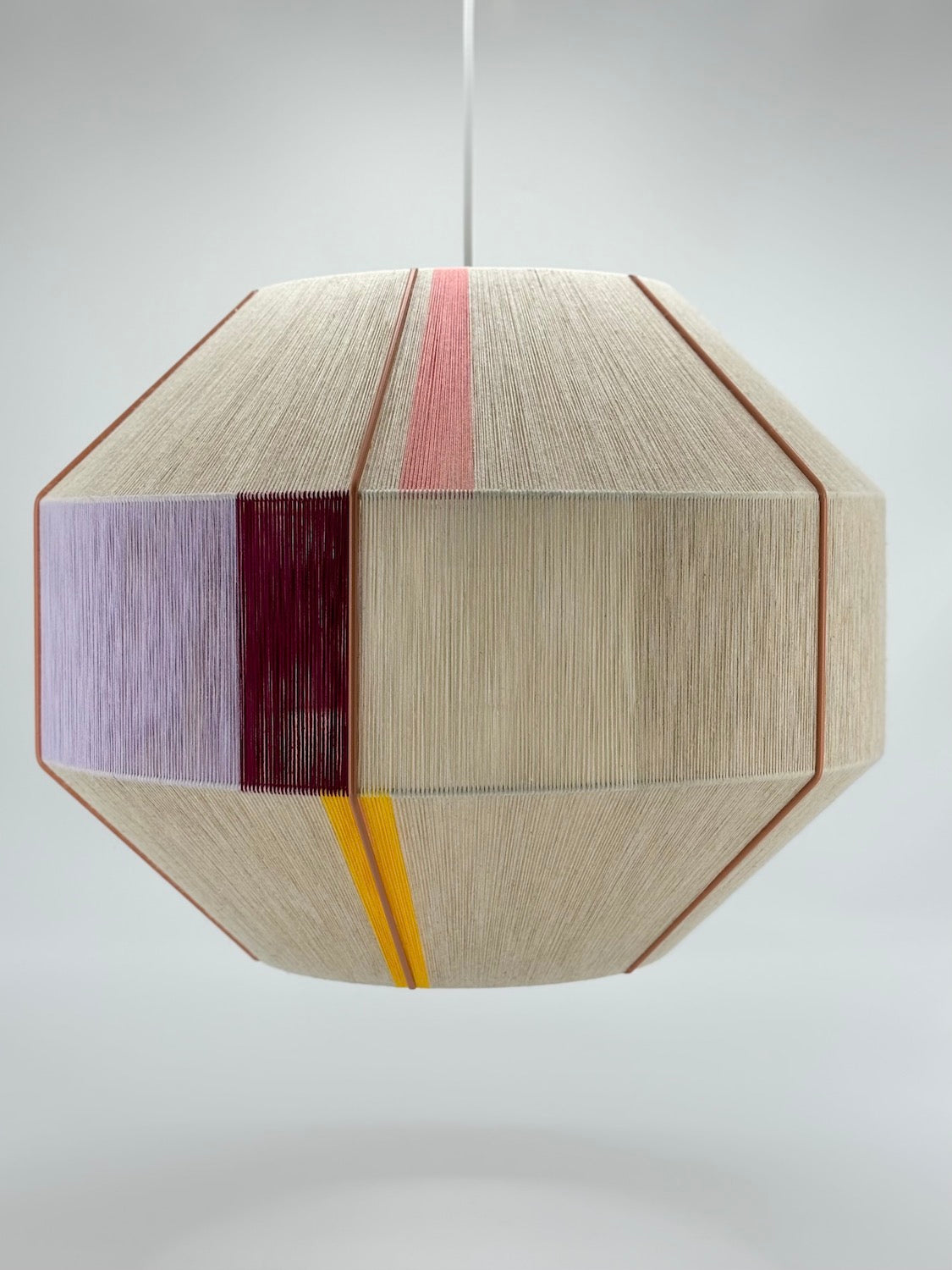 Middle view of Bella Hive pendant light handwoven in salmon, lavender, buttercup yellow, raspberry and natural yarns by Skye Lightly