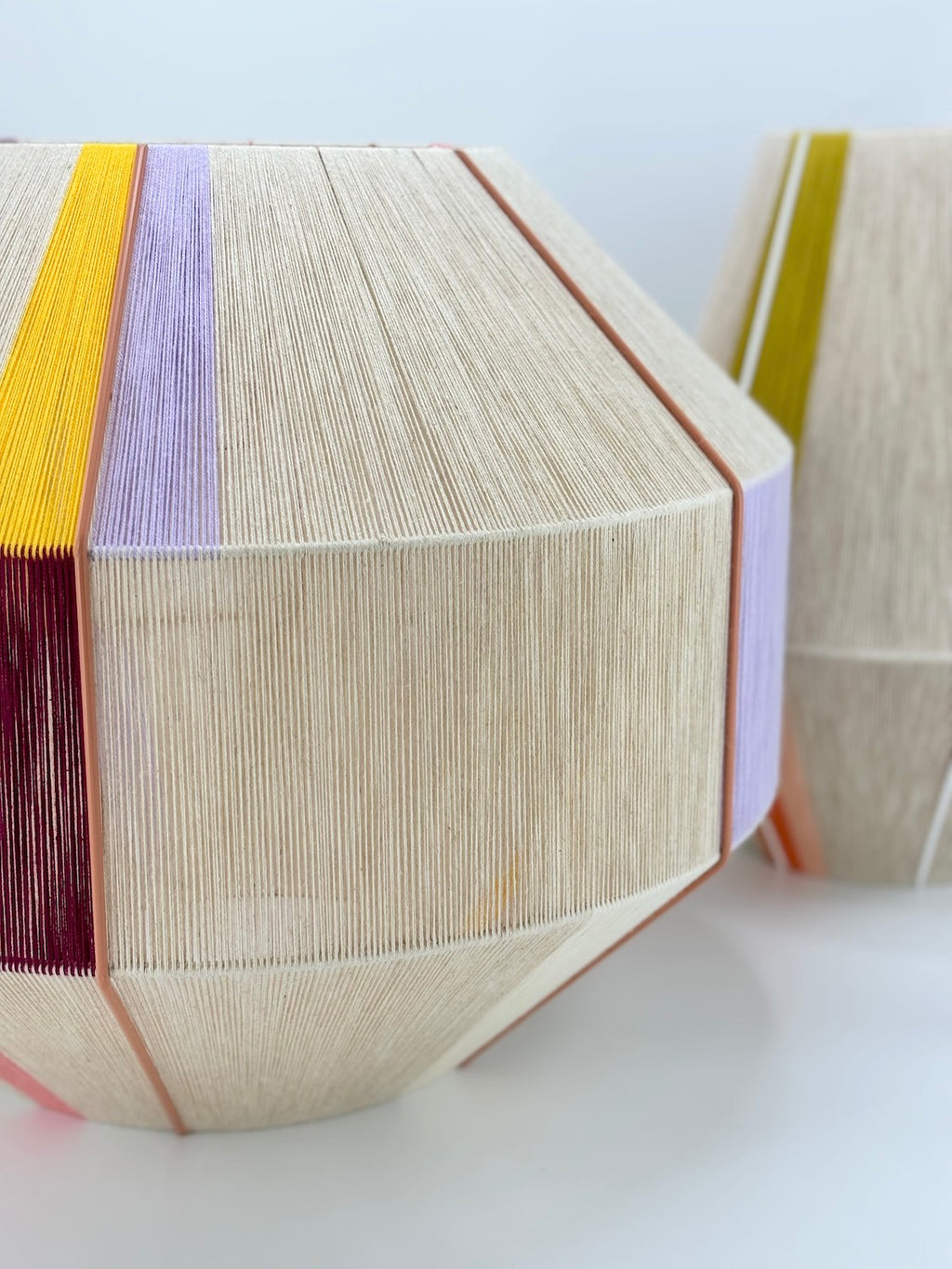 Right side of Bella Hive pendant light handwoven in salmon, lavender, buttercup yellow, raspberry and natural yarns by Skye Lightly
