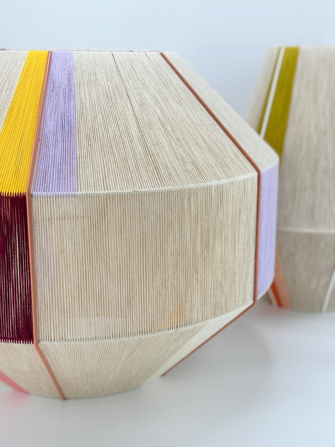 Right side of Bella Hive pendant light handwoven in salmon, lavender, buttercup yellow, raspberry and natural yarns by Skye Lightly