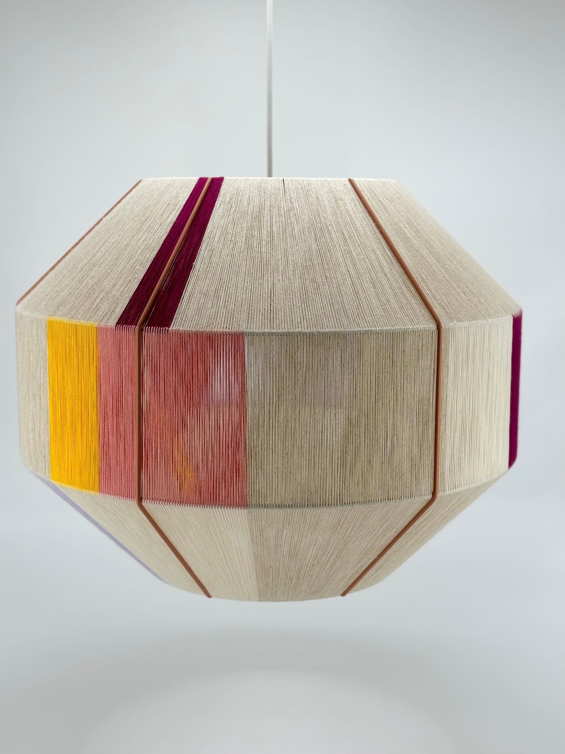 Bella Hive pendant light handwoven in salmon, buttercup yellow, raspberry and natural yarns by Skye Lightly