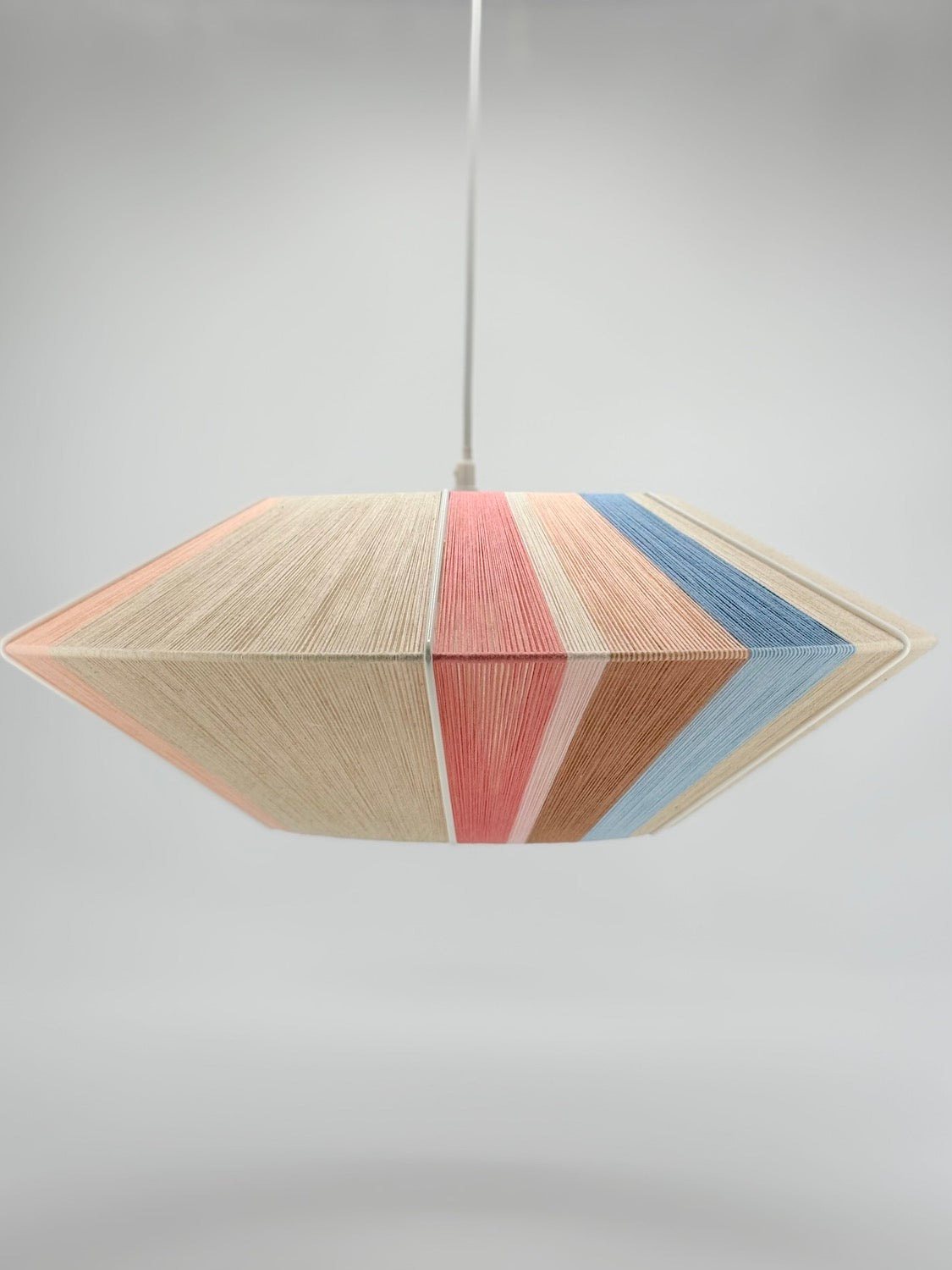 side middle view of Jean Orb pendant light handwoven in cinnamon, peach, chambray, salmon, pale rose and natural yarns by Skye Lightly