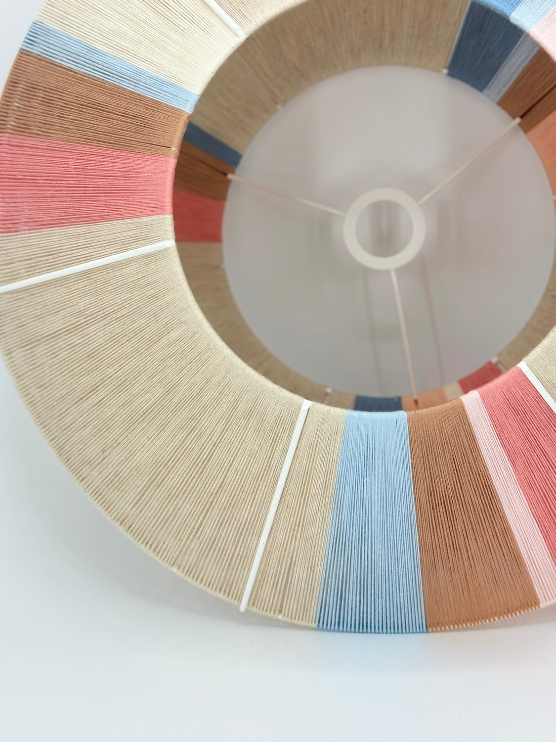 close top view of Jean Orb pendant light handwoven in cinnamon, peach, chambray, salmon, pale rose and natural yarns by Skye Lightly