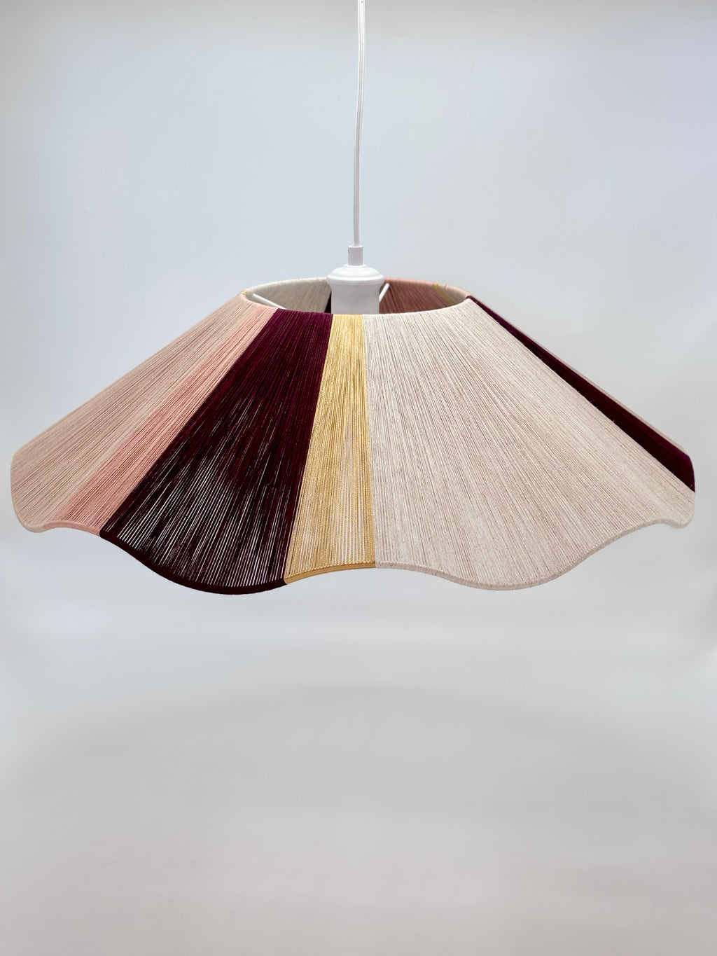 Handwoven cottesloe Wave pendant light in burgundy, blush, gold and natural yarns by Skye Lightly.