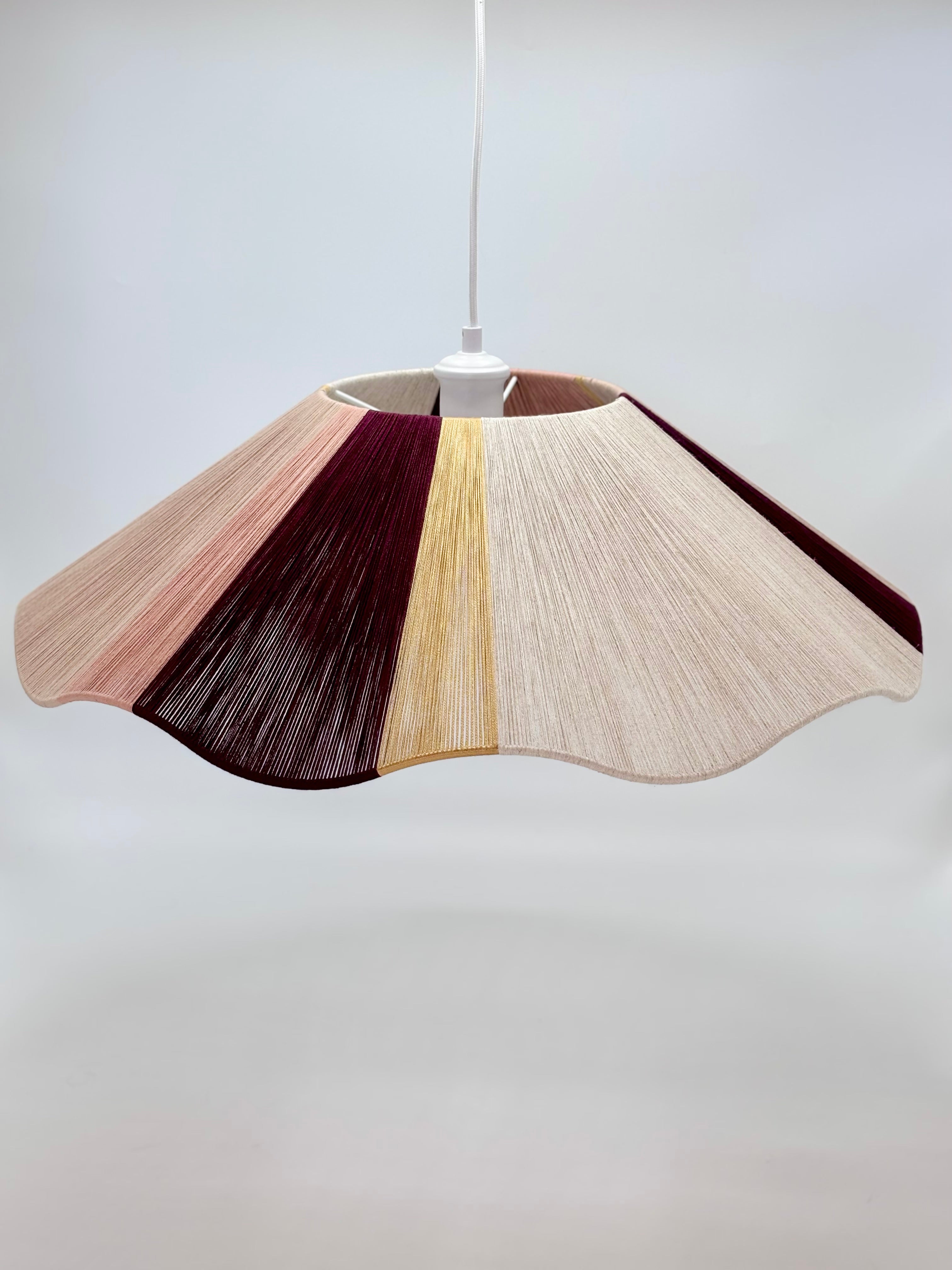 Handwoven cottesloe Wave pendant light in burgundy, blush, gold and natural yarns by Skye Lightly.