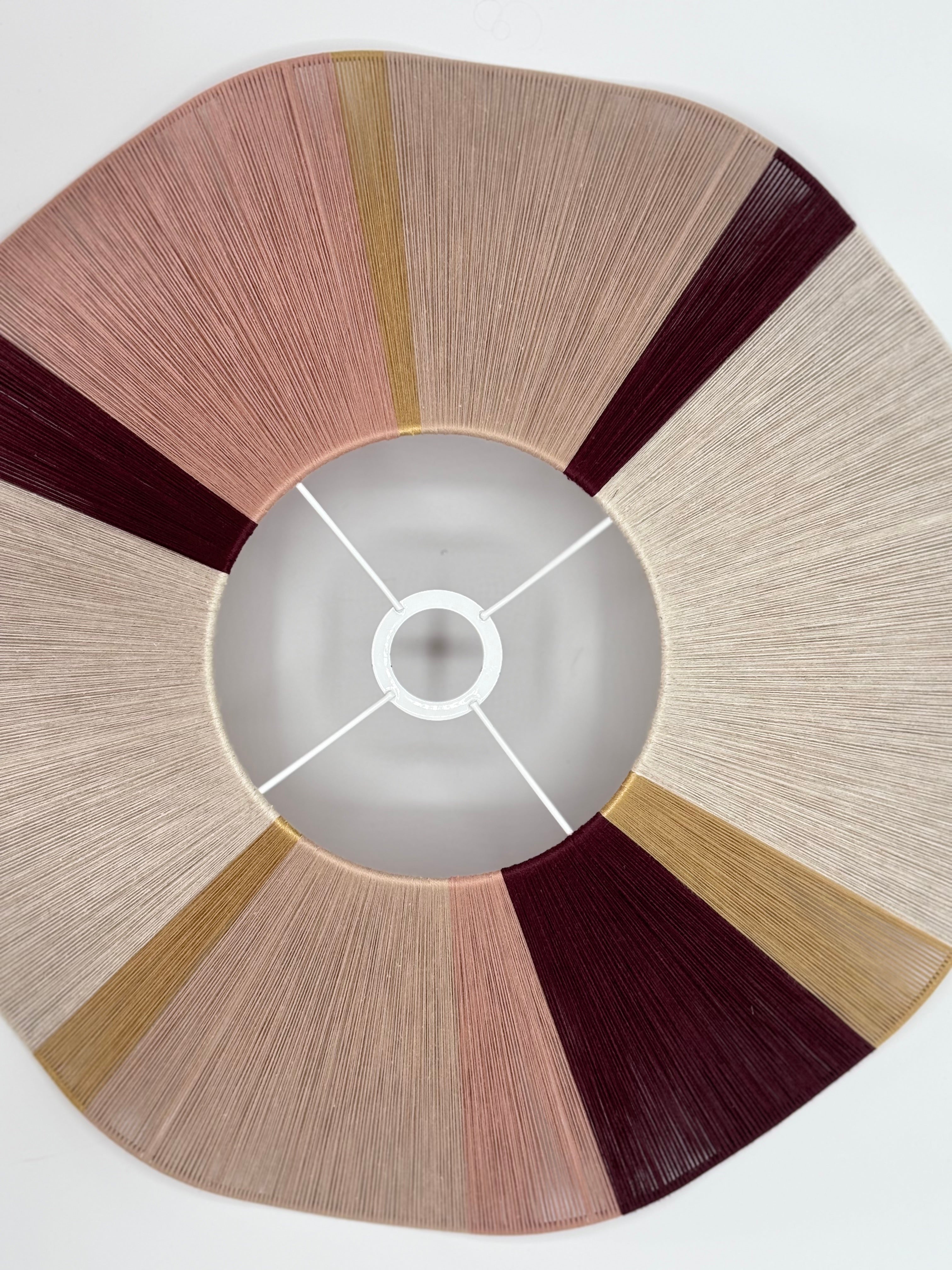 top view of handwoven cottesloe Wave pendant light in burgundy, blush, gold and natural yarns by Skye Lightly.