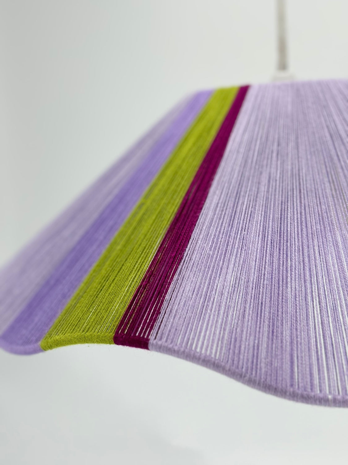 side view of iona Wave pendant light in lilac with green and raspberry stripes, handwoven by Skye Lightly.