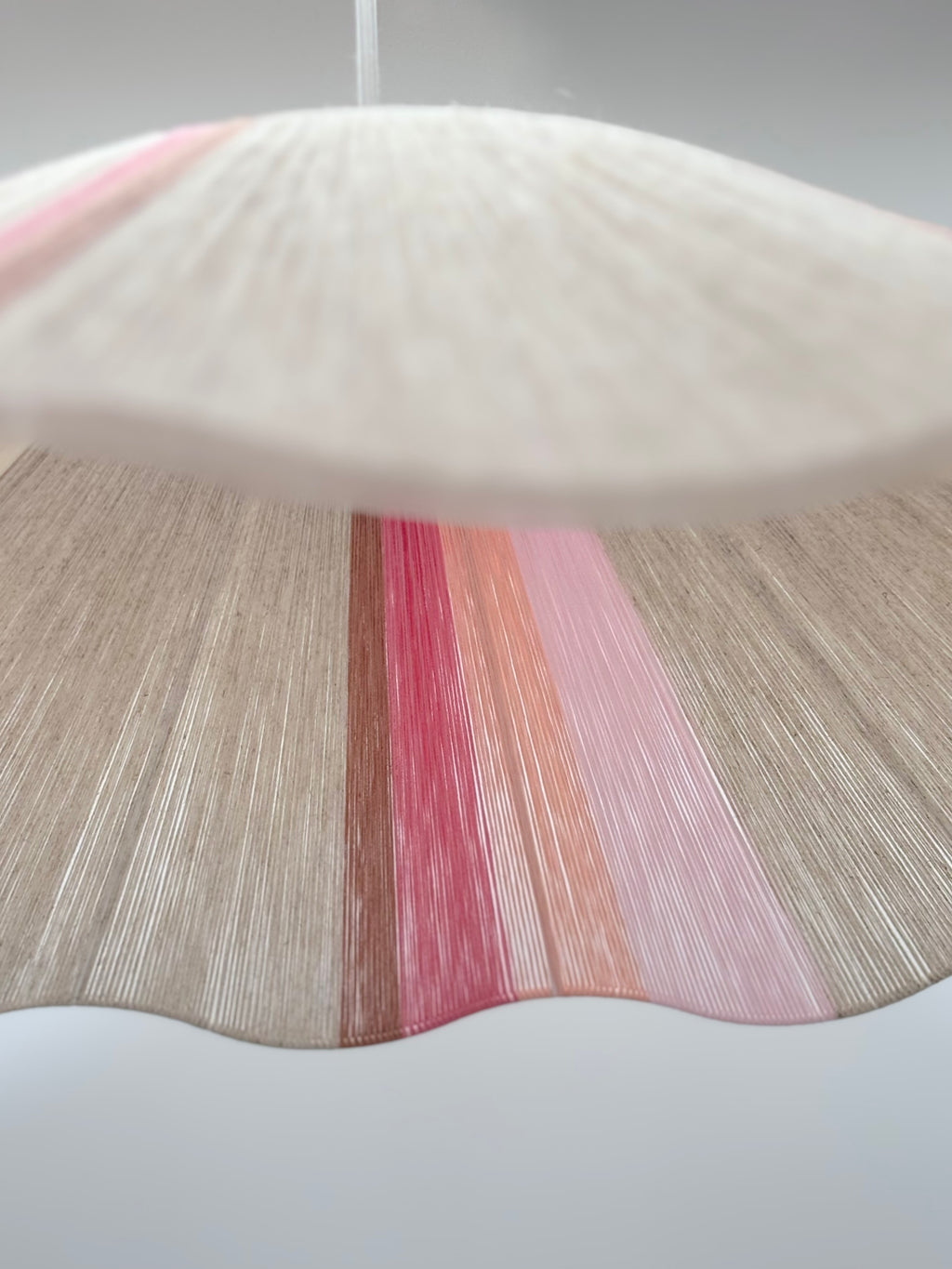 Bottom view of handwoven Knox wave pendant light in soft pink and natural tones by Skye Lightly.
