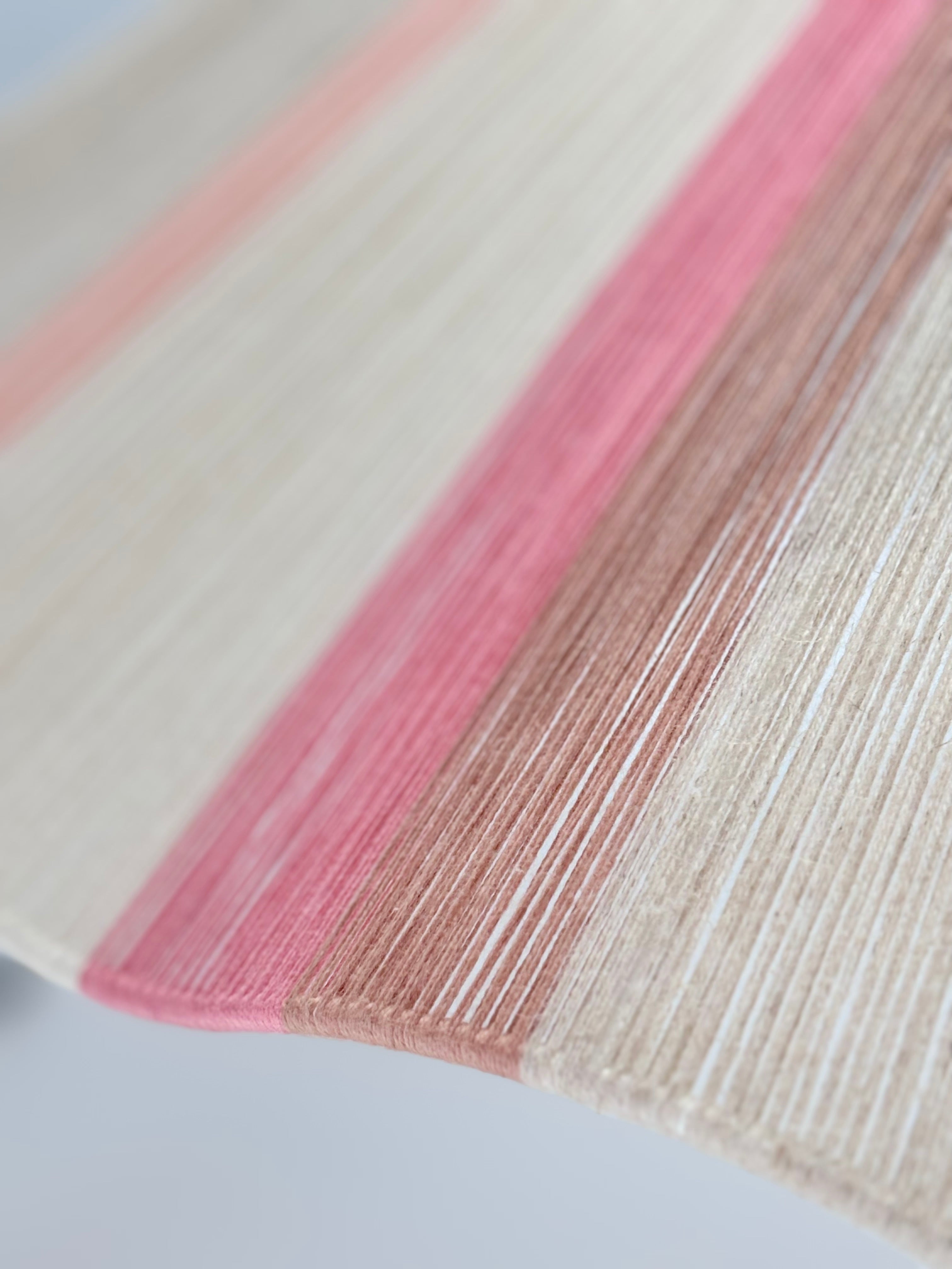 Yarn closeup of handwoven Knox wave pendant light in soft pink and natural tones by Skye Lightly
