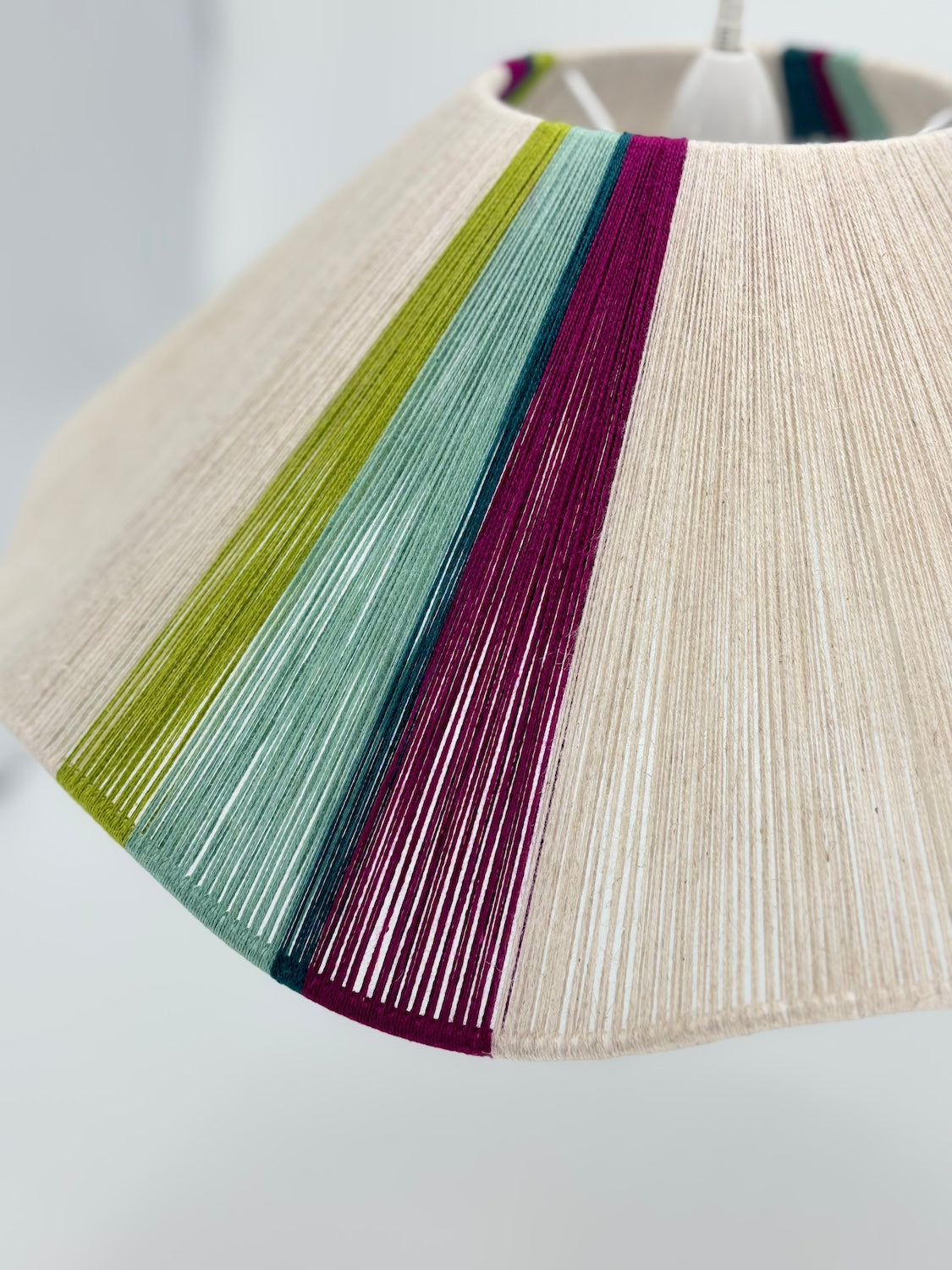 closeup of sono Wave pendant light handwoven in lime, magenta, teal, turquoise and natural yarns by Skye Lightly,