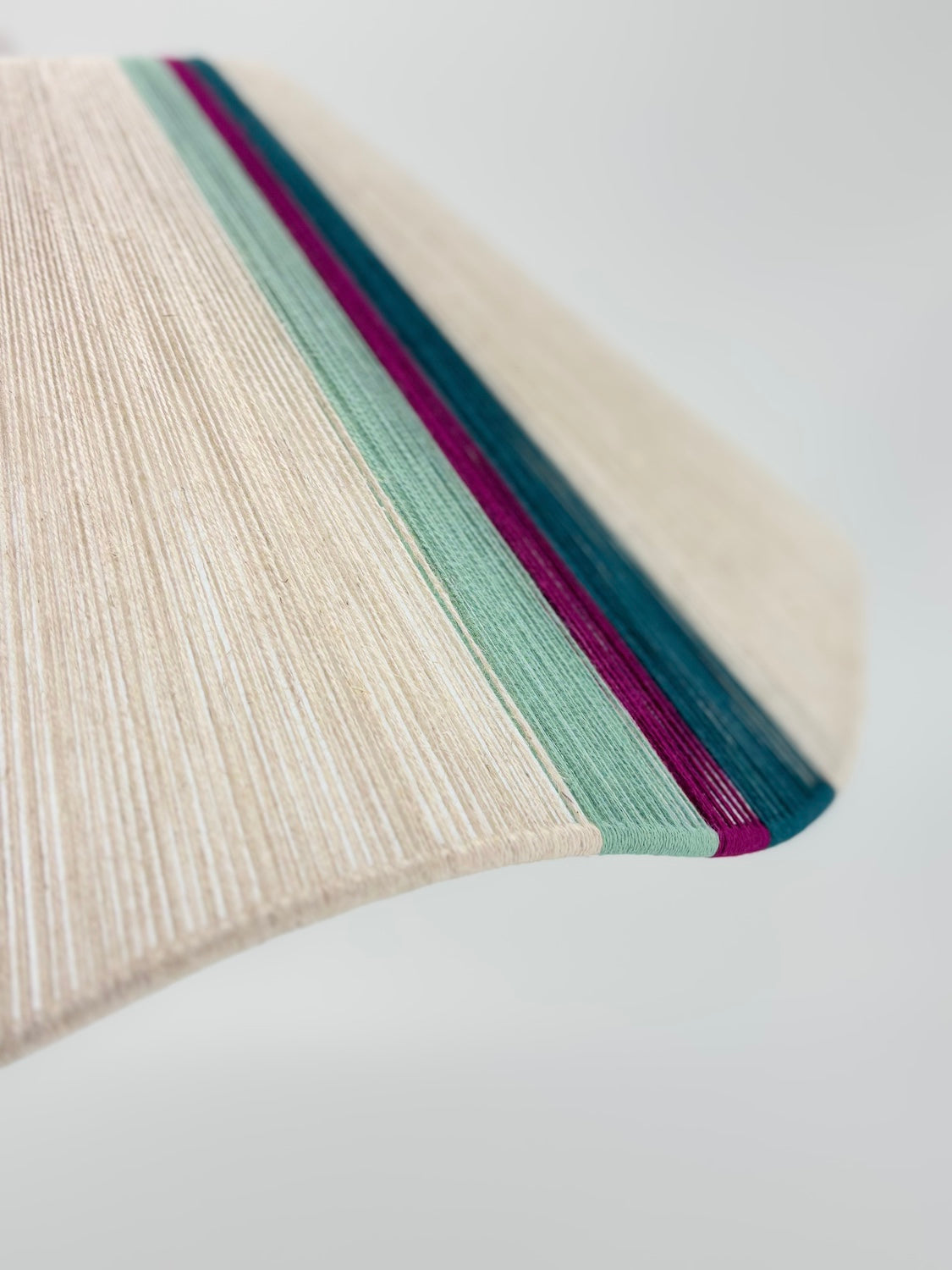 side view sono Wave pendant light handwoven in lime, magenta, teal, turquoise and natural yarns by Skye Lightly.