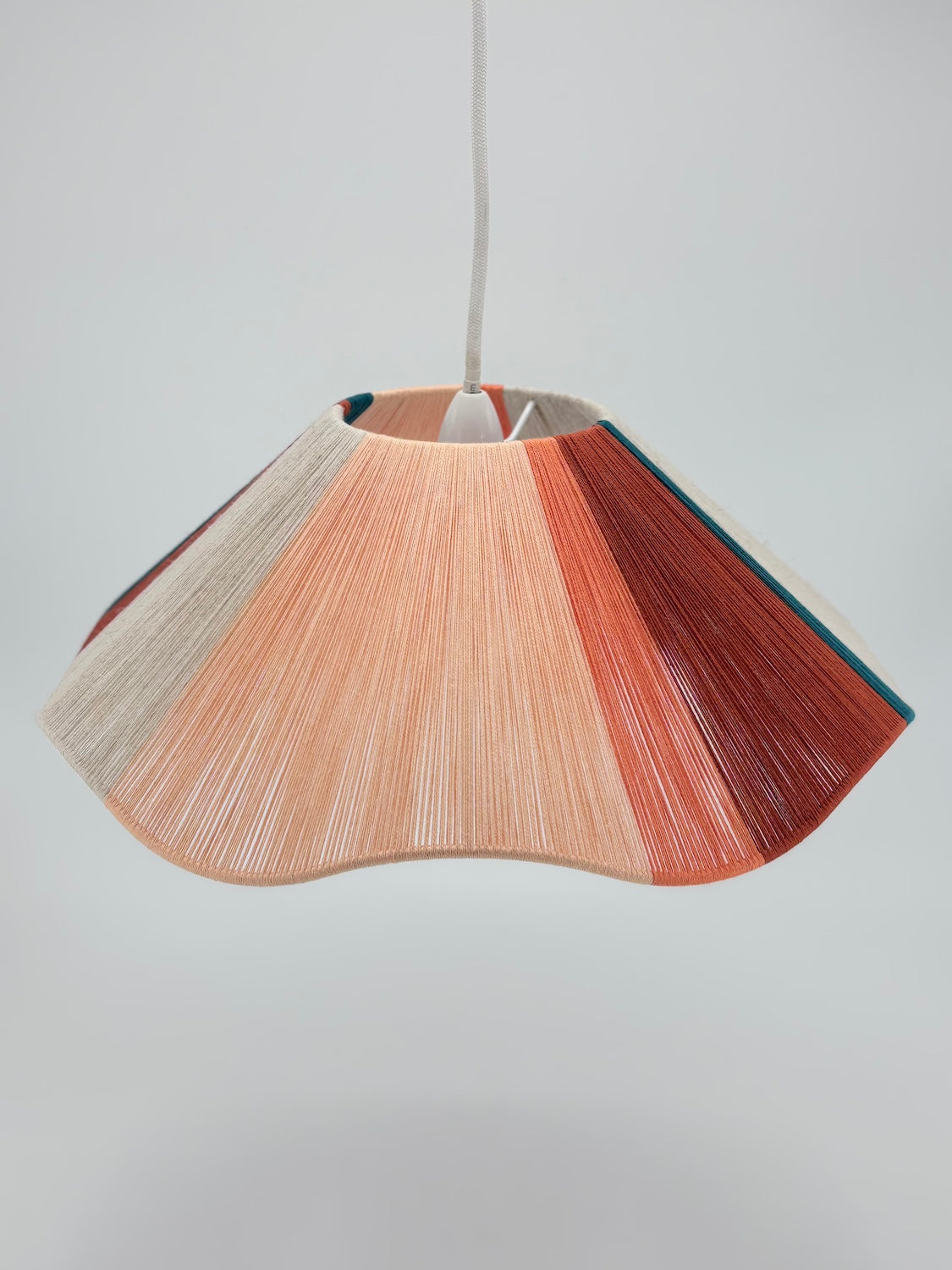 top view of venice Wave pendant light handwoven in peach, teal, burgundy and natural yarns by Skye Lightly.