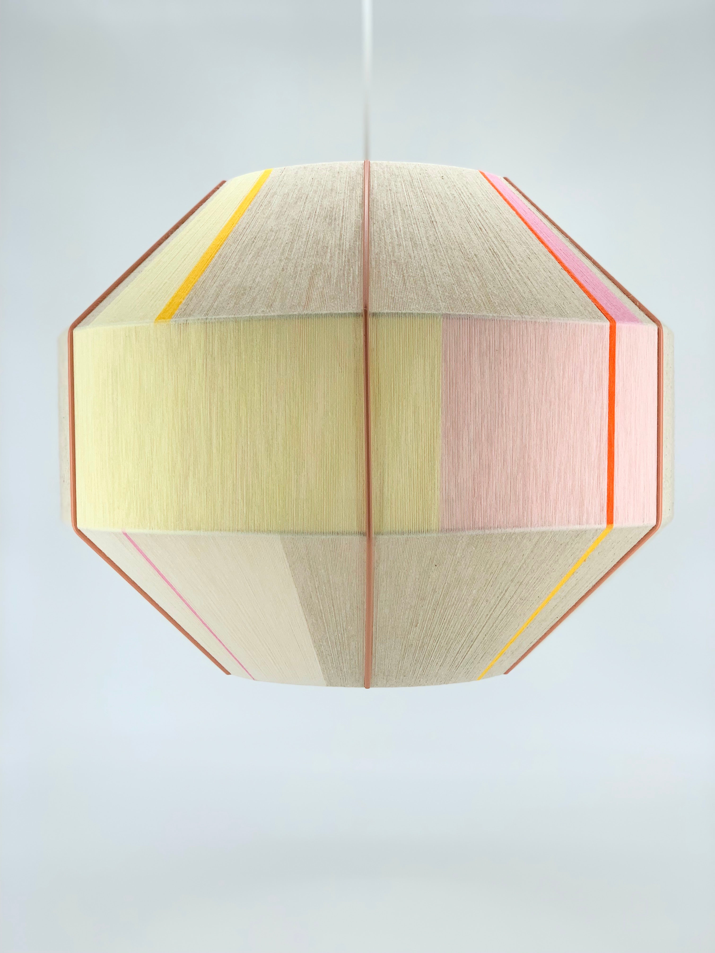 Amor Hive pendant light handwoven in blush, eucalyptus, lilac and natural yarns by Skye Lightly
